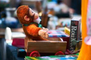 pluszowa małpka siedząca na stosie książek