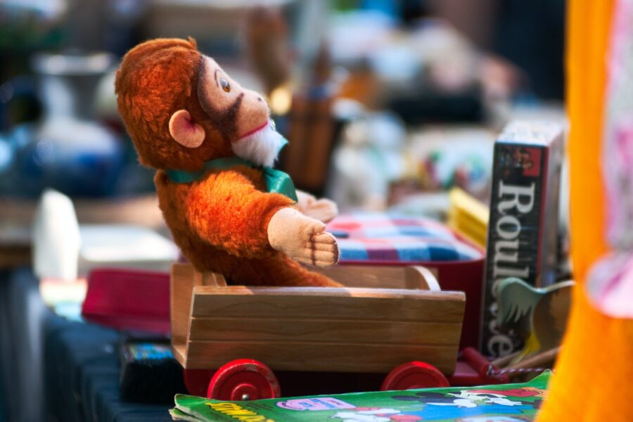 a stuffed toy monkey sitting on a stack of books